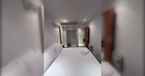 Ein Hotelzimmer mit einem großen Bett, einem begehbaren Kleiderschrank und einer Tür zu einem Badezimmer.