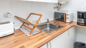 A kitchen with a wooden countertop, a sink, a toaster, a coffee maker, and a power outlet. - In the centre and near the beach (Fuengirola)