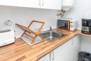 A kitchen with a wooden countertop, a sink, a toaster, a coffee maker, and a power outlet. - In the centre and near the beach (Fuengirola)