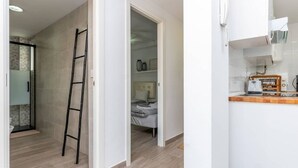 A room with a wooden floor, a ladder, a bed, and a kitchenette area. - In the centre and near the beach (Fuengirola)