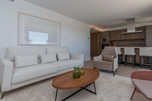 Ein modernes Wohnzimmer mit einer Couch, einem Couchtisch und einem Sessel.