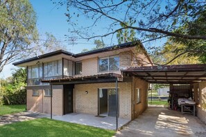 A two-story house with a covered garage, a front porch, and a well-maintained lawn.