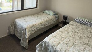 A bedroom with two beds, a window, and a ceiling fan. - Riverview Retreat 3 BDR house 2 toilets (Riverview)