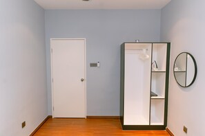 A room with a white door, a wardrobe with shelves, and a mirror on the wall. - Trival Misty Cottage Homestay @ Sri Indah Sandakan (Sandakan)