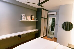 A bedroom with a bed, a ceiling fan, a shelf with framed pictures, a wardrobe, and an air conditioning unit. - Trival Misty Cottage Homestay @ Sri Indah Sandakan (Sandakan)