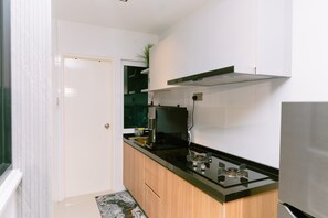 A modern kitchen with white cabinets, a black countertop, and a stainless steel range hood. - Trival Misty Cottage Homestay @ Sri Indah Sandakan (Sandakan)