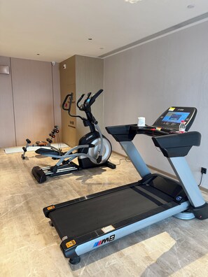 A gym with treadmills, an elliptical, and a stationary bike.