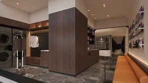 A modern hotel lobby with a central seating area, a laundry facility, and a wall with framed pictures. - Jinglai Hotel Shanghai Yuyuan Xintiandi Lujiabang Road Metro (Shanghai)