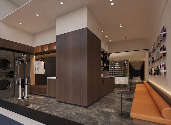 A modern hotel lobby with a central seating area, a laundry facility, and a wall with framed pictures. - Jinglai Hotel (Chenghuang Xintiandi Lujiabang Metro) (Shanghai)