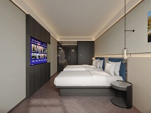 Ein modernes Hotelzimmer mit einem großen Bett, einem kleinen Nachttisch, einem an der Wand befestigten Fernseher und einem separaten Badebereich.