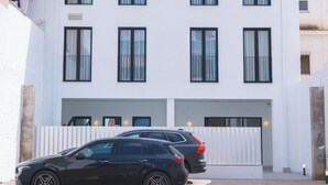 A modern two-story building with a flat roof, six windows, and a car parked in front. - Two-bedroom apartment (Picaña)