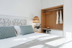 Een moderne slaapkamer met een bed, een kledingkast en een nachtkastje.
