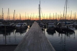 Un port de plaisance où des bateaux sont amarrés le long d’une jetée en bois.