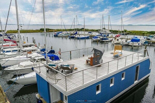 A marina with docked boats and a blue boat with a deck area. - Holiday home in Kragenaes with terrace (Kragenaes)