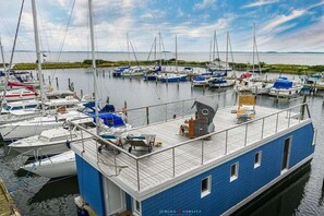 Een jachthaven met aangemeerde boten en een blauwe boot met een dek.