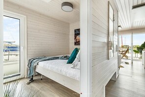 A room with a bed, a window, and a view of the outside. - Holiday home in Kragenaes with terrace (Kragenaes)