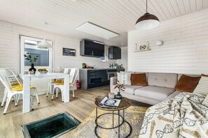 A modern apartment with a dining area, kitchen, and living room. - Holiday home in Kragenaes with terrace (Kragenaes)