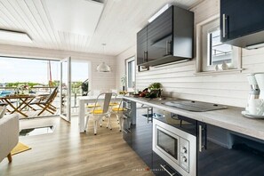 A modern kitchen with a large island, built-in appliances, and a view to the outside. - Holiday home in Kragenaes with terrace (Kragenaes)