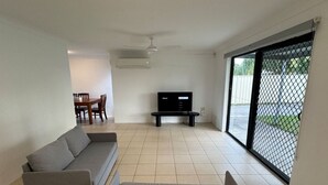 A living room with a sofa, a TV, and a dining table. - Family-friendly home—feel right at home. (Crestmead)