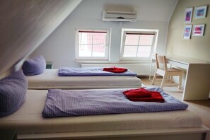 A dormitory room with two beds, a desk, and two windows. - Holiday apartment with 3 bedrooms (Prerow)