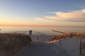 A beach with a wooden walkway, a lifeguard tower, and sand dunes. - Holiday apartment with 3 bedrooms (Prerow)
