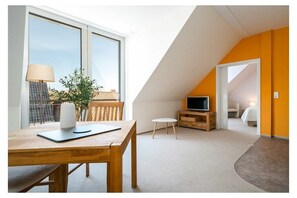A modern room with a dining table, a TV, and a bed. - Holiday apartment in Mirow with sauna (Mirow)