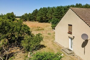 A single-story house with a sloped roof, a satellite dish, and a small window. - Holiday apartment at Müritz (Rechlin)