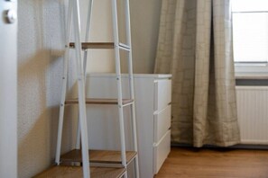 A white ladder leaning against a wall with a white cabinet below it. - Holiday apartment at Müritz (Rechlin)