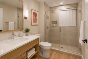 A modern bathroom with a shower, toilet, and vanity. - The Vionelle Hotel (Toronto)
