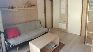 Un salón acogedor con sofá, una mesa de centro y una lámpara colgante.