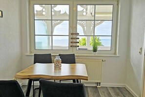En matplats med ett bord och stolar, ett fönster med utsikt och ett element.
