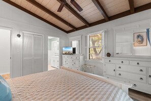 A bedroom with a bed, dresser, television, and a window with blinds. - Family Beach Escape 5BR Fenced Yard, Walk to Ocean (Pawleys Island)