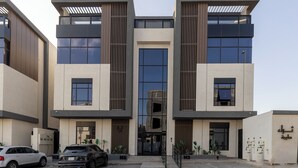 A modern building with a symmetrical facade, large windows, and a central entrance. - Elegant Studio Near Quba Mosque Prime Location (Madinah)