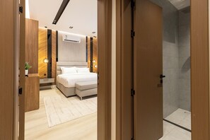 A modern bedroom with a bed, bedside tables, and a shower area. - Elegant Studio Near Quba Mosque Prime Location (Madinah)