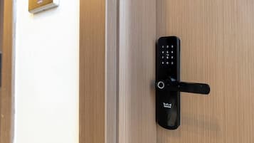 A modern door with a digital keypad lock and a doorbell.