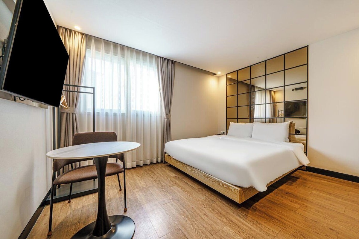 Una habitación de hotel con una cama, un escritorio y un televisor.