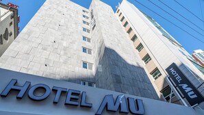 En modern byggnad med en tydlig skylt som visar texten ”HOTEL MU”.