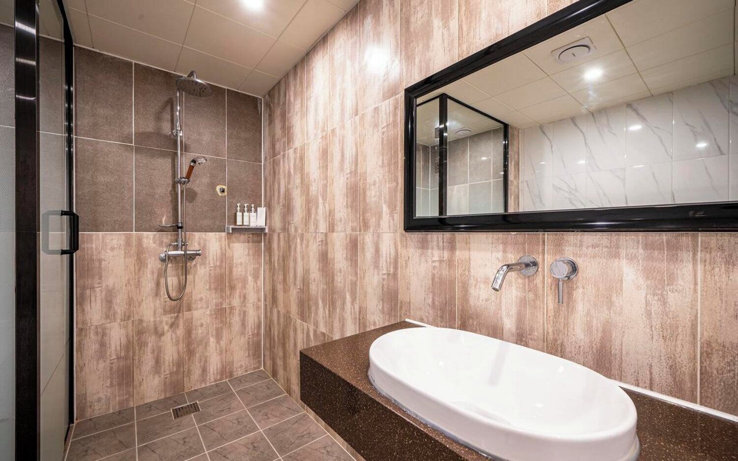 A modern bathroom with a shower, a bathtub, and a large mirror.