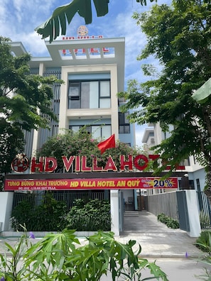 L'ingresso di un hotel dal design moderno, con una bandiera e uno striscione promozionale.