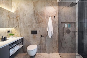A modern bathroom with a marble wall, a toilet, a shower, and a vanity with a towel rack. - Villa 22 .. (ZADAR)