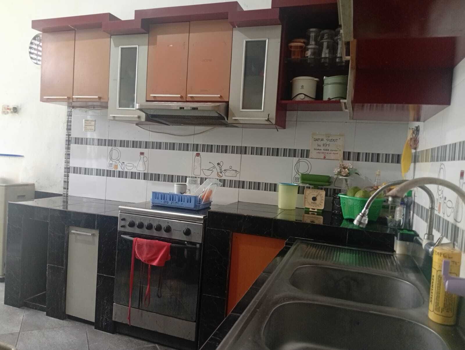 A kitchen with a stove, oven, sink, and cabinets.