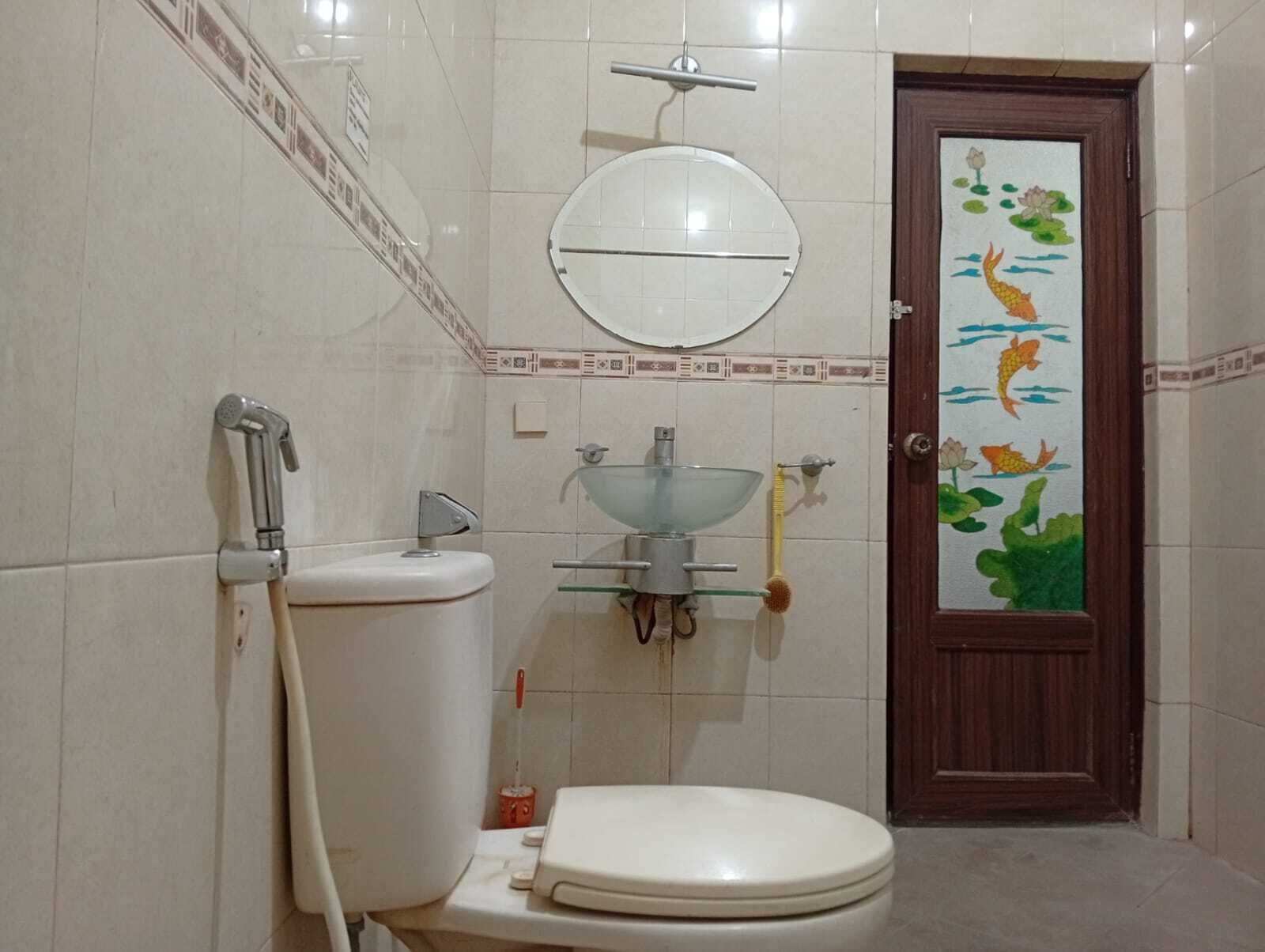 A bathroom with a toilet, a sink, a mirror, and a shower.