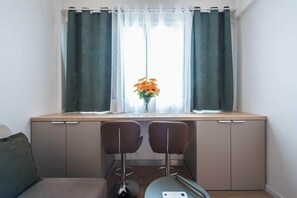 A small kitchenette with a window, two chairs, and a vase with flowers. - Stylish Studio KingBed&Workspace-WkndNse (Athina)