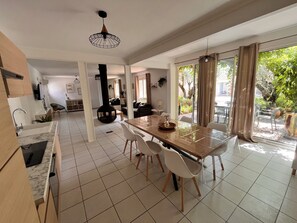 Una cocina amplia con comedor, ventanas grandes y vistas al exterior.
