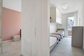 A modern bedroom with a bed, bedside tables, and a wardrobe. - Apartment 'Villa Luna 8' in Lido di Jesolo, Barrier-Free, Parking, Pet-Friendly (Lido di Jesolo)