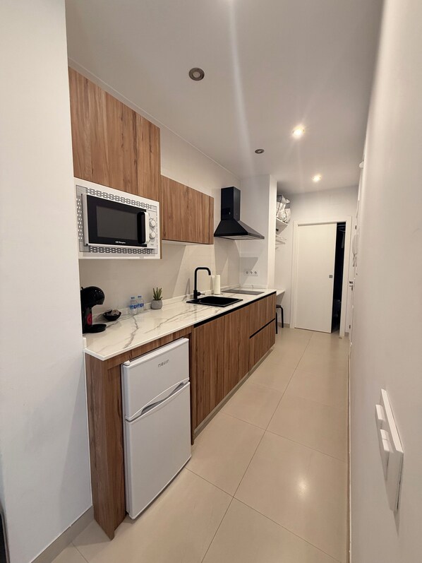 Una cocina moderna con microondas integrado, fregadero y lavavajillas.