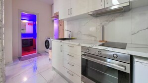 Eine moderne Küche mit weißen Schränken, einem Edelstahlbackofen und einer eingebauten Mikrowelle.