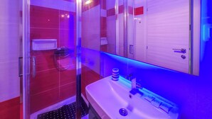 Ein Badezimmer mit Duschkabine, Waschbecken und Spiegel.