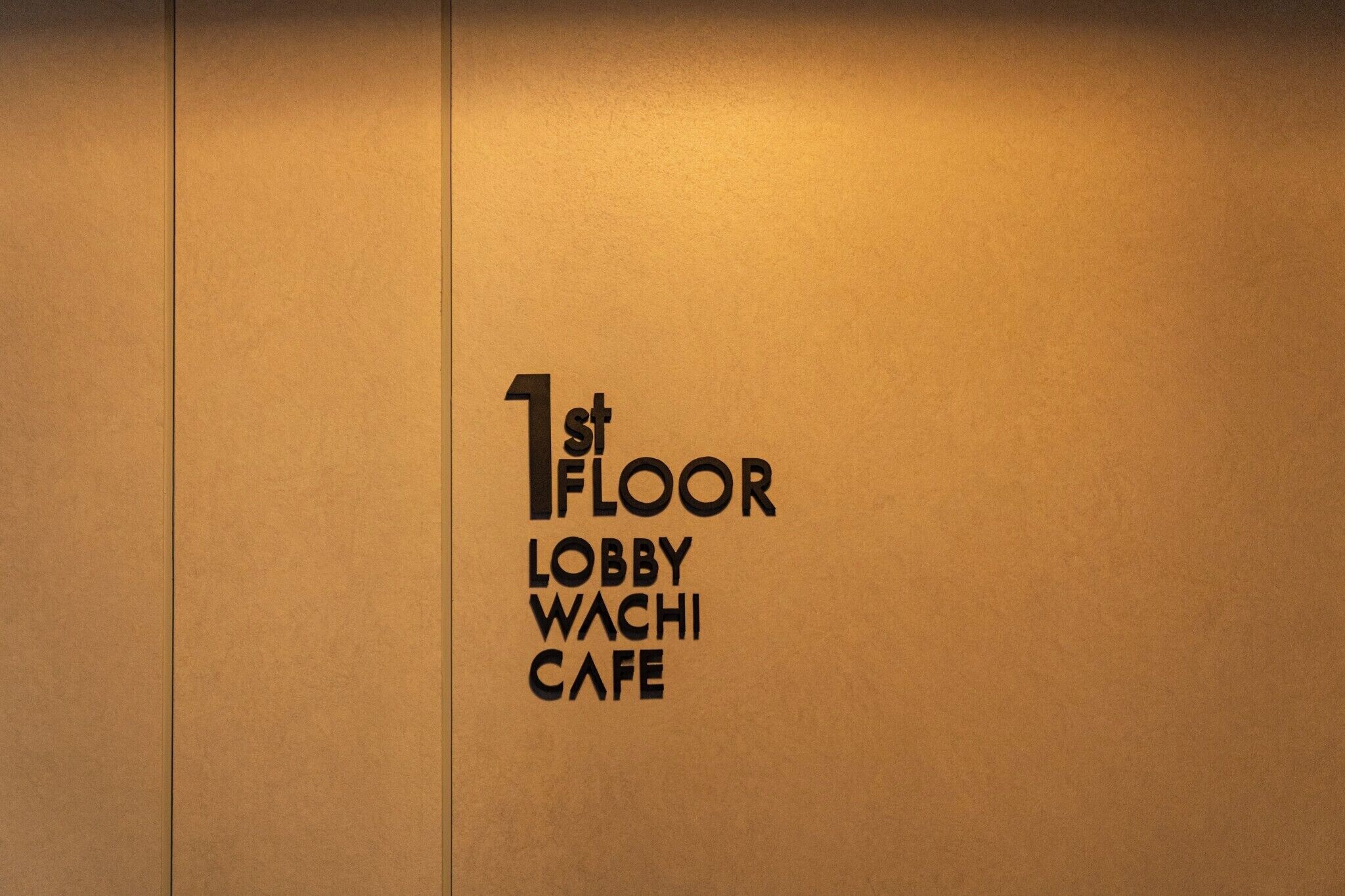 Pared con el texto '1st FLOOR LOBBY WACHI CAFE' que indica la ubicación dentro de un edificio.