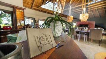 A wooden table with a paper bag, a potted plant, and a pen.